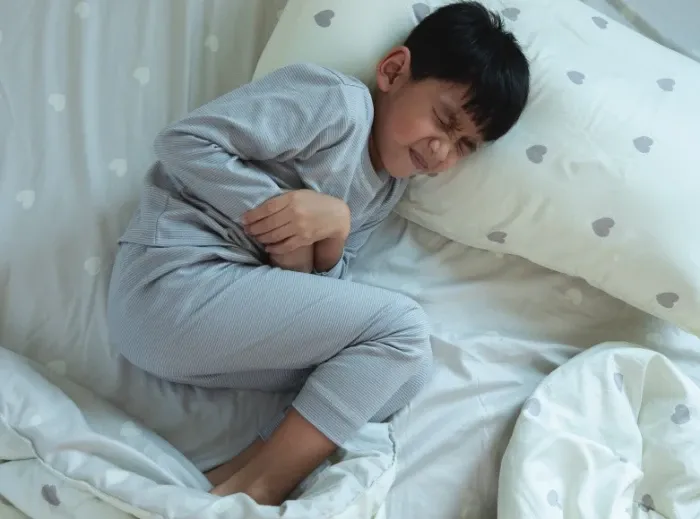 Uma pessoa segurando um pequeno frasco próximo à boca.