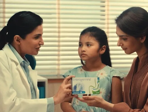 Uma pessoa segurando um pequeno frasco próximo à boca.